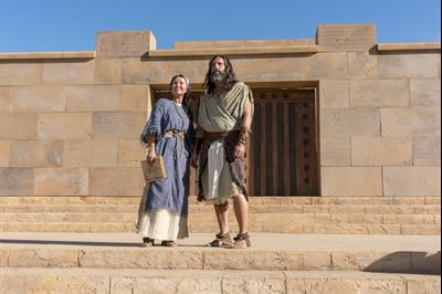 Nephi and his wife standing on the steps of the temple. Image via churchofjesuschrist.org.