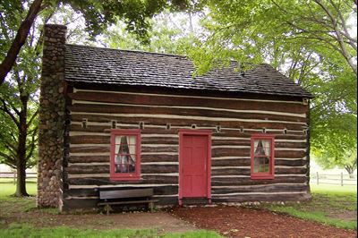 A recreation of the Whitmer family's log home. Image via Wikimedia Commons.